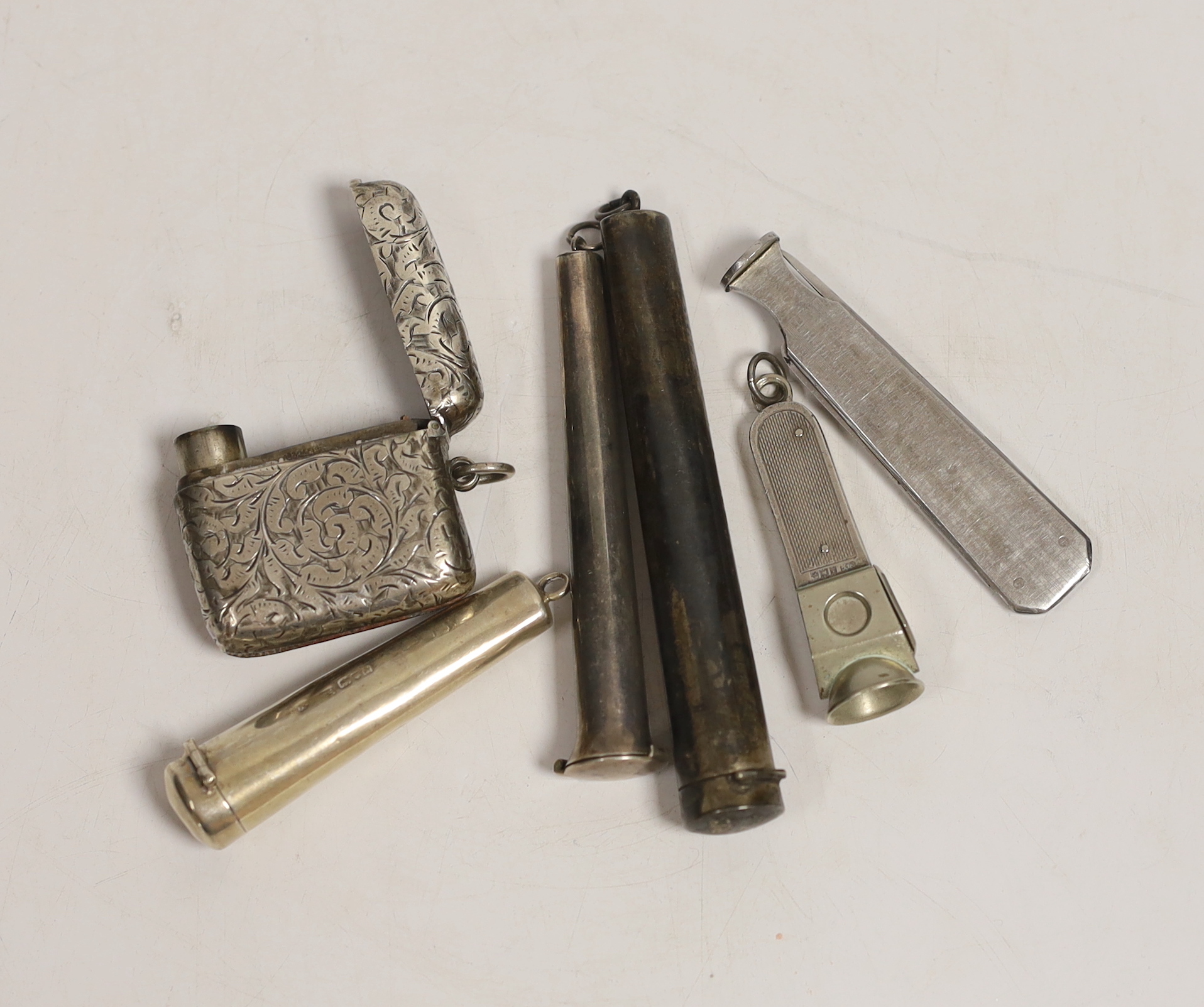 A late Victorian silver combination vesta case/cigar cutter, Birmingham, 1898, 46mm, three silver cheroot holder cases, a silver mounted cigar cutter and one other item.